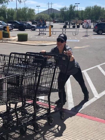 Person smiling while pushing shopping carts
